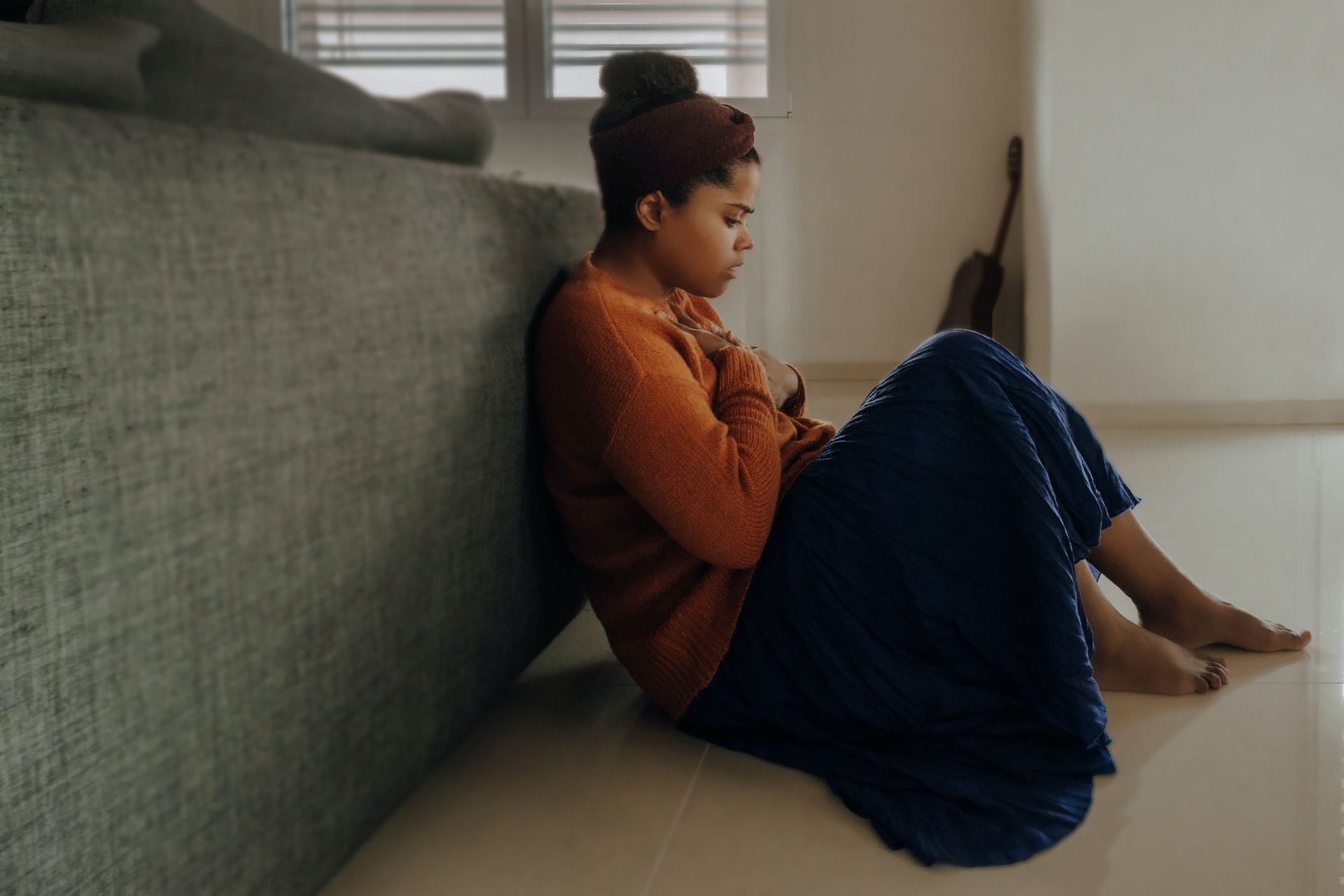 Young woman sitting down on the floor looking worried