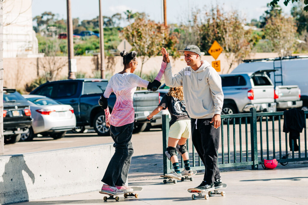 Skate boarders high fiving each other in an urban environment